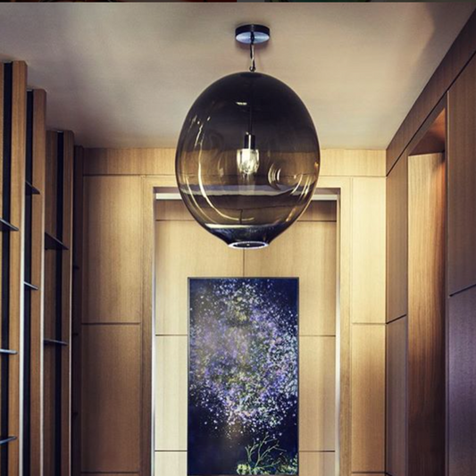 Modern interior with a hanging glass pendant light and wall art.